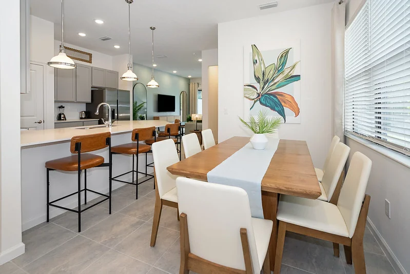 3BR Storey Lake townhome open kitchen-dining: white shaker cabinets, four-seat round table, no styling clutter.