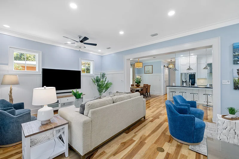 Open-concept living, dining, and kitchen with coordinated turnkey vacation rental furniture package