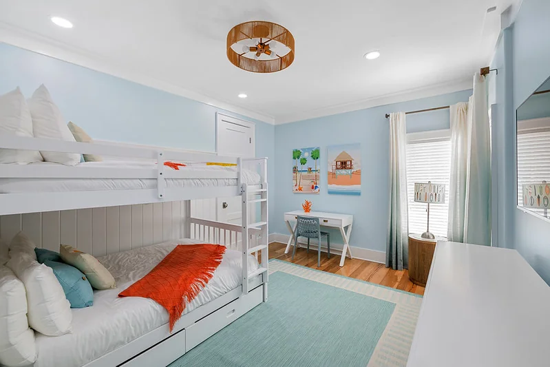 Kids bedroom: two twin beds with light-grey duvets + coastal pillow each, shared nightstand. No theme.