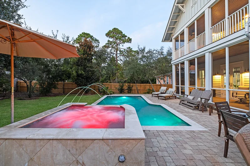 Pool deck and screened lanai at golden hour staged for Airbnb listing photography